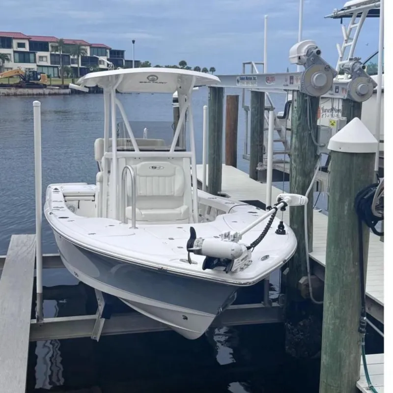 Slide: The Image of 2022 Sea Hunt BX 22 boat docked at marina, calm waters, overcast sky. - 0