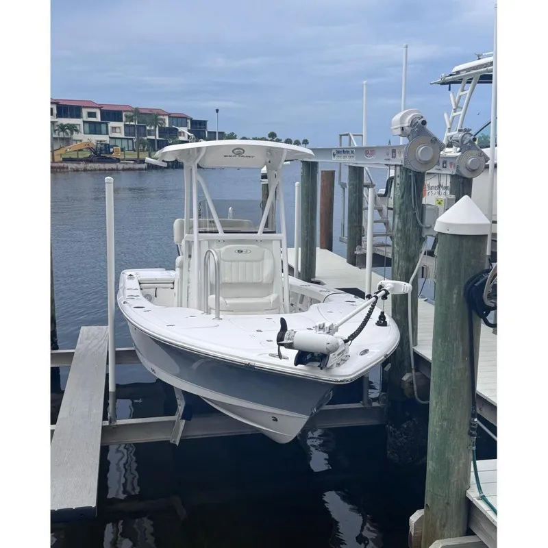 Slide: The Image of 2022 Sea Hunt BX 22 boat docked at marina, calm waters, overcast sky. - 1