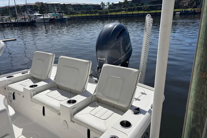 Slide: The Image of 2022 Sea Hunt BX 22 Pro boat with Yamaha engine, docked by calm waters. - 10
