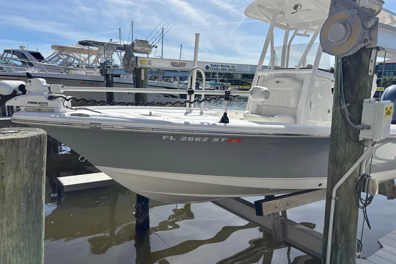 Slide: The Image of 2022 Sea Hunt BX 22 boat docked at marina, featuring Minn Kota trolling motor. - 2