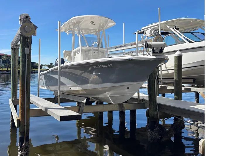 Slide: The Image of 2022 Sea Hunt BX 22 boat docked on a sunny day, reflecting on calm water. - 3