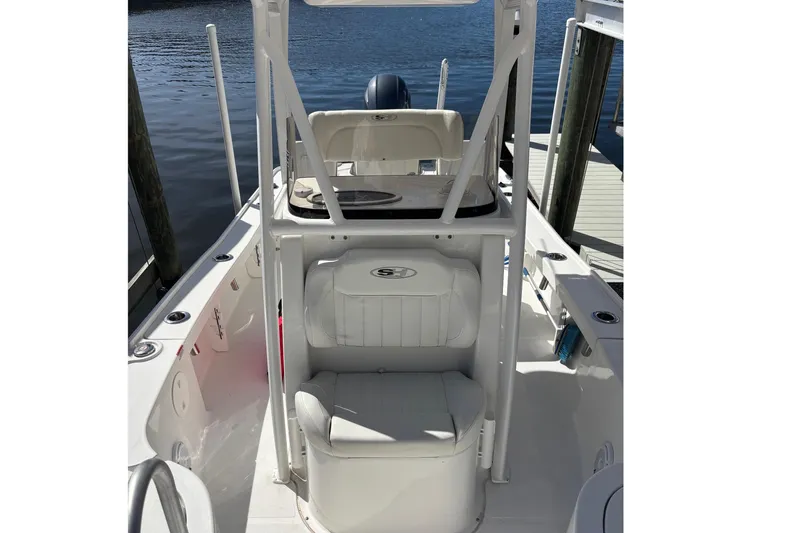 Slide: The Image of 2022 Sea Hunt BX 22 Pro boat interior with seating and console, docked by the water. - 8