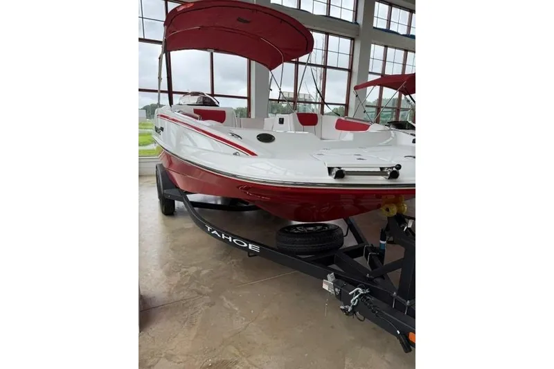 Slide: The Image of 2026 Tahoe 1950 boat with red and white design on trailer indoors. - 1
