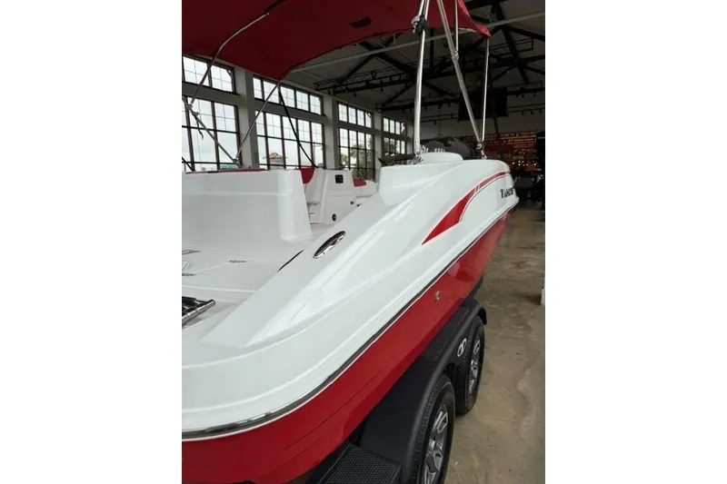 Slide: The Image of 2026 Tahoe 1950 boat in showroom, featuring red and white design with canopy. - 3