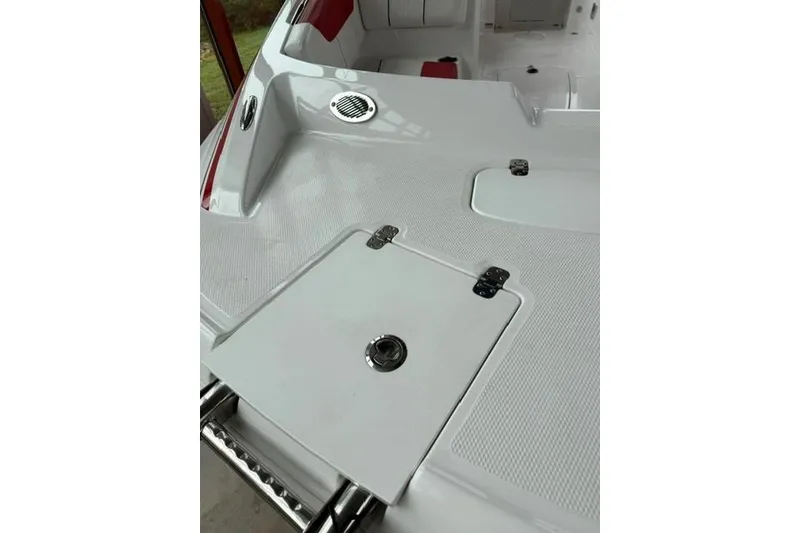Slide: The Image of 2026 Tahoe 1950 boat deck with storage hatch and red seating accents. - 10