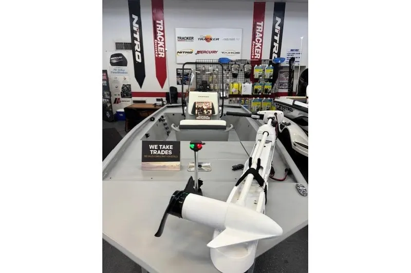 Slide: The Image of 2026 Tracker Bass Tracker Classic CC boat displayed in showroom with trade-in sign. - 2