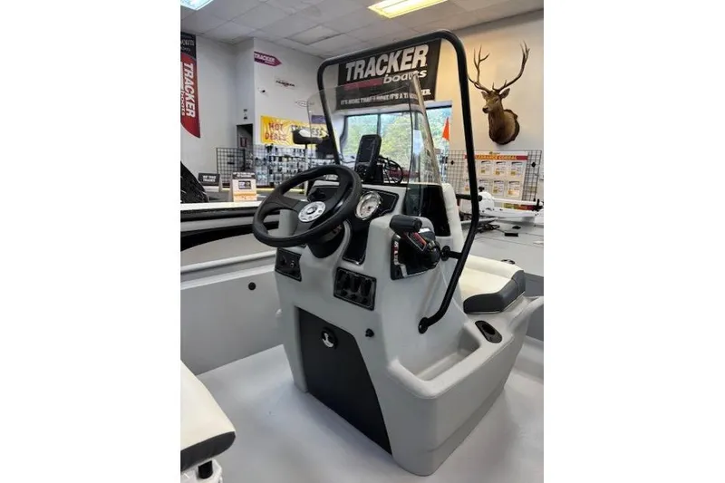 Slide: The Image of 2026 Tracker Bass Tracker Classic CC boat console in showroom with steering wheel and controls. - 4
