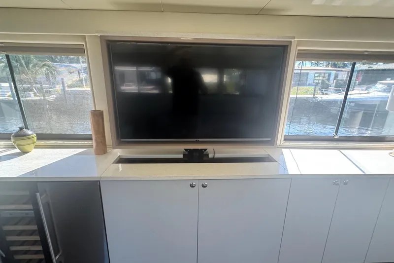 Slide: The Image of Interior of 1989 Hatteras 65 Motor Yacht with TV and windows overlooking water. - 10