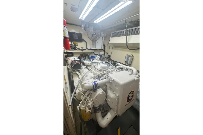 Slide: The Image of Engine room of a 1989 Hatteras 65 Motor Yacht with visible machinery and equipment. - 14