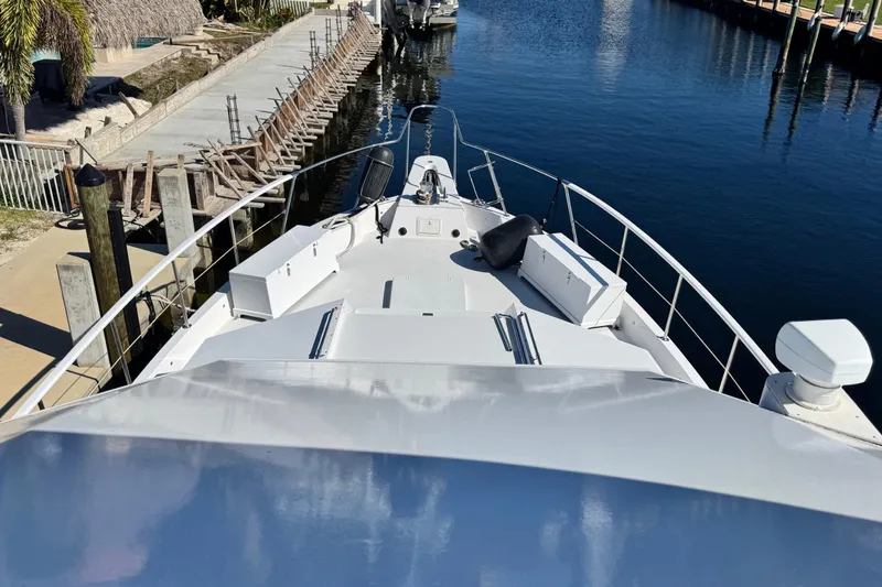 Slide: The Image of 1989 Hatteras 65 Motor Yacht docked in a serene marina setting. - 17