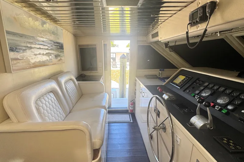 Slide: The Image of Interior of 1989 Hatteras 65 Motor Yacht with helm, steering wheel, and seating area. - 4