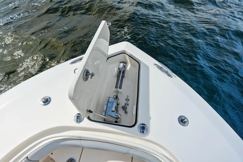 Slide: The Image of 2020 Scout 355 LXF boat anchor compartment open on calm water. - 17