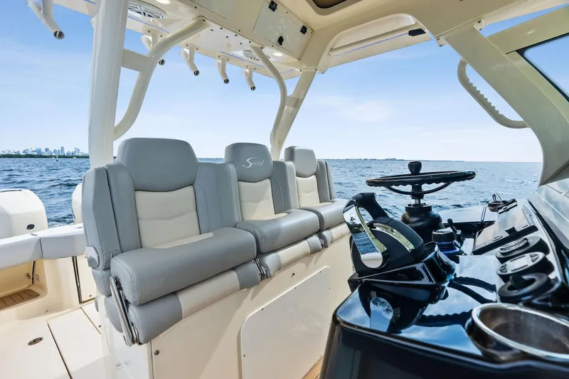 Slide: The Image of 2020 Scout 355 LXF boat interior with luxury seating and steering, ocean view. - 20