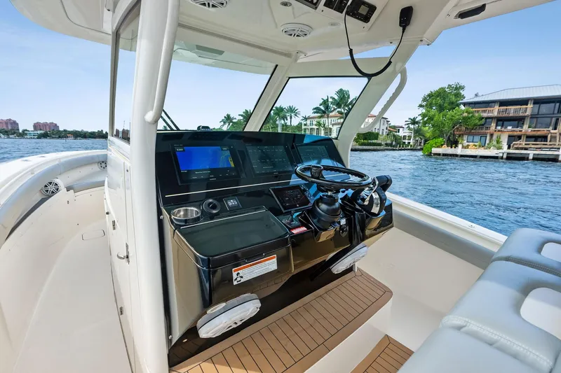 Slide: The Image of 2020 Scout 355 LXF boat helm with modern controls and waterfront view. - 22