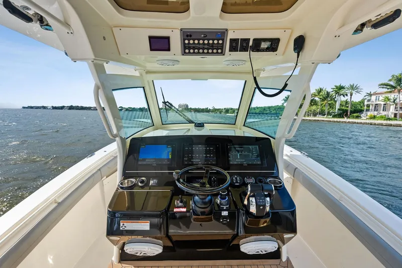 Slide: The Image of 2020 Scout 355 LXF boat helm with advanced navigation system on open water. - 23
