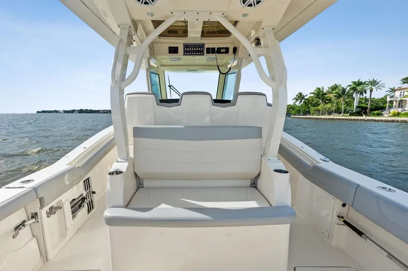Slide: The Image of 2020 Scout 355 LXF boat interior with seating, ocean view, and palm trees. - 30