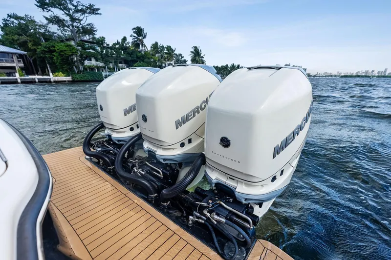 Slide: The Image of Triple Mercury outboard engines on a 2020 Scout 355 LXF boat, docked by the water. - 33
