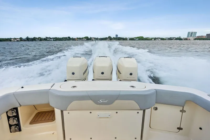 Slide: The Image of 2020 Scout 355 LXF boat with triple engines cruising on open water. - 34