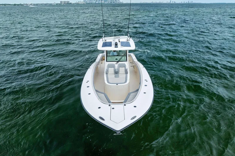 Slide: The Image of 2020 Scout 355 LXF boat on open water, showcasing sleek design and spacious deck. - 5