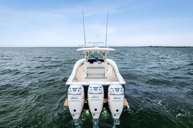 Slide: The Image of 2020 Scout 355 LXF boat with triple engines cruising on open water. - 6