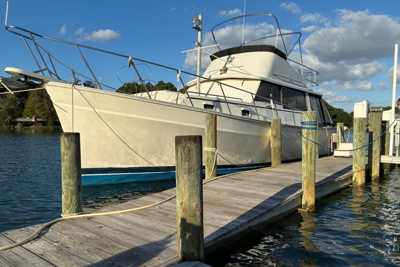 The Image of 1982 Mainship 34 MK 1 docked at a marina under a clear blue sky. - 0