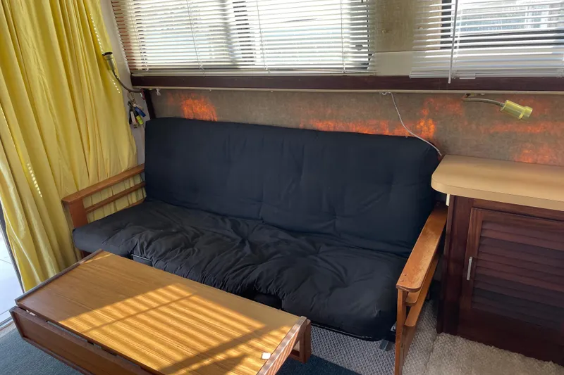 Slide: The Image of Interior of 1982 Mainship 34 MK 1 with black futon and wooden table. - 14