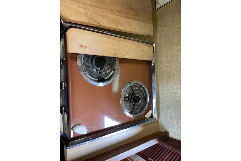 Slide: The Image of 1982 Mainship 34 MK 1 stove with wooden cover and dual burners. - 23