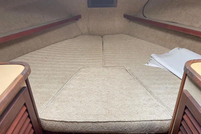 Slide: The Image of 1982 Mainship 34 MK 1 cabin interior with beige upholstery and wooden accents. - 27