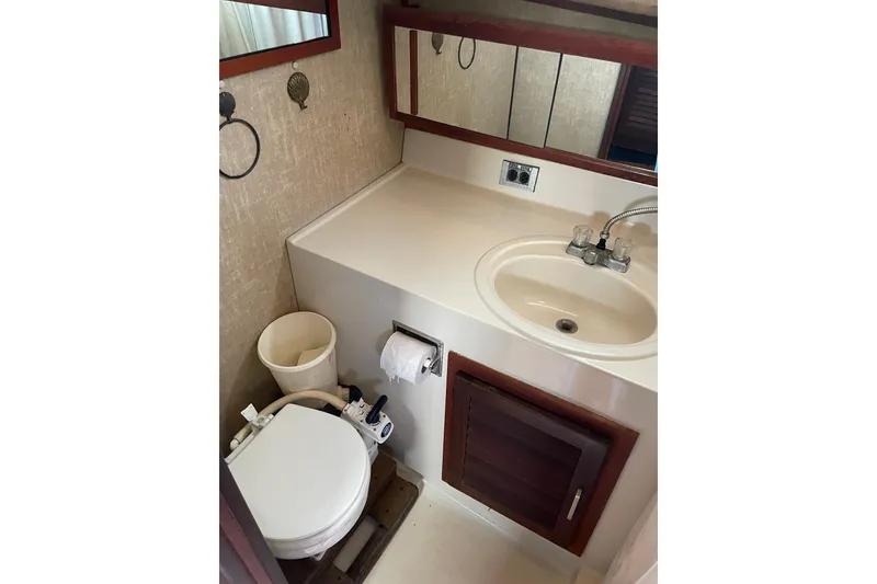 Slide: The Image of Compact bathroom in 1982 Mainship 34 MK 1 boat with sink and toilet. - 29