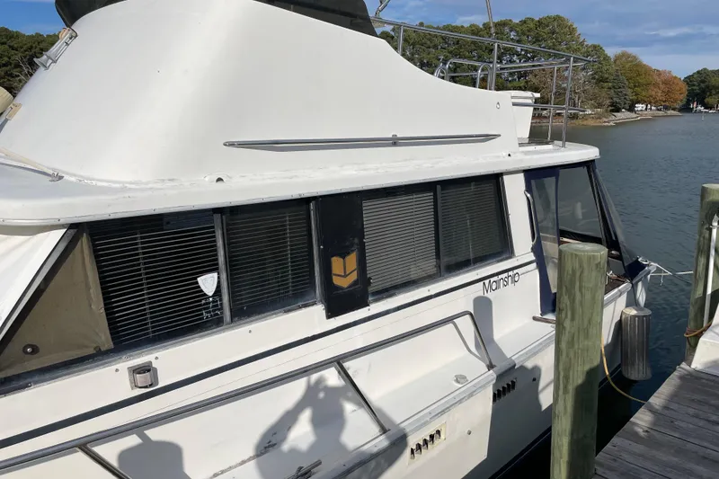 Slide: The Image of 1982 Mainship 34 MK 1 docked by a serene waterfront. - 3