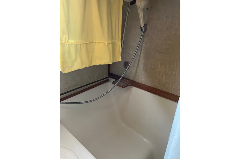 Slide: The Image of Shower area in 1982 Mainship 34 MK 1 boat with yellow curtain and handheld showerhead. - 30