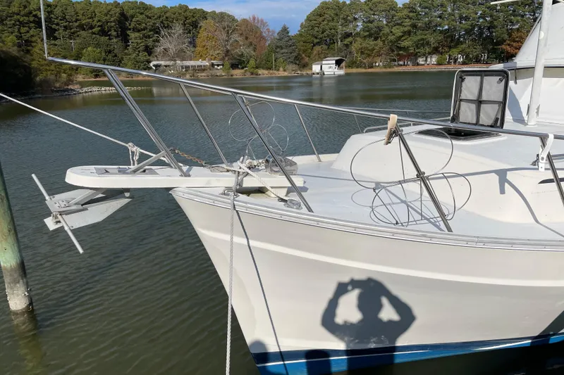 Slide: The Image of 1982 Mainship 34 MK 1 boat docked on a calm lake with trees in the background. - 5