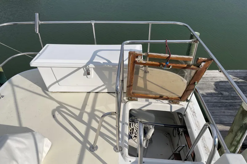 Slide: The Image of 1982 Mainship 34 MK 1 boat deck with storage and railing, docked by water. - 7