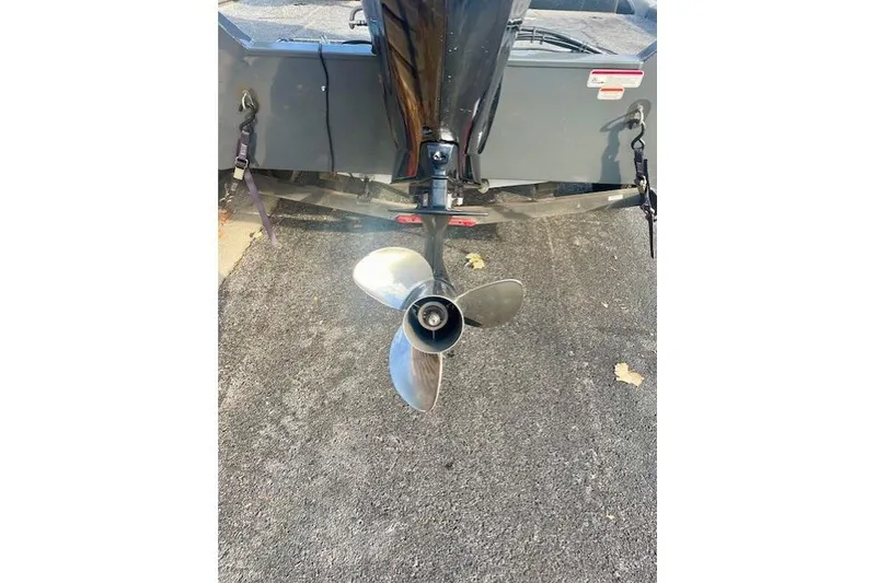 Slide: The Image of 2017 Tracker Pro Team 195 TXW boat propeller on asphalt surface. - 8