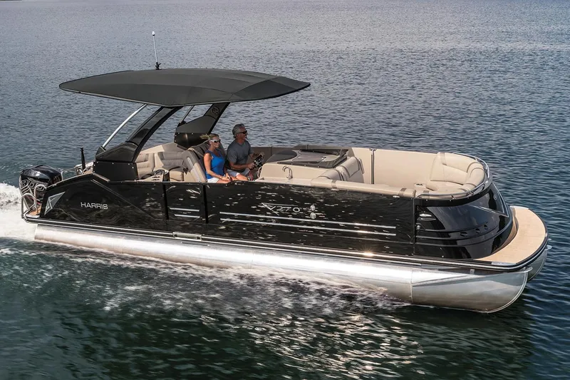 Slide: The Image of 2018 Harris V270 pontoon boat docked, featuring sleek blue design and spacious seating. - 0