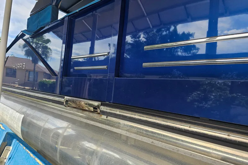 Slide: The Image of 2018 Harris V270 pontoon boat docked under a canopy. - 14