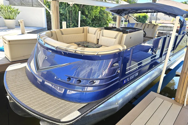 Slide: The Image of 2018 Harris V270 pontoon boat docked under a canopy on a sunny day. - 15