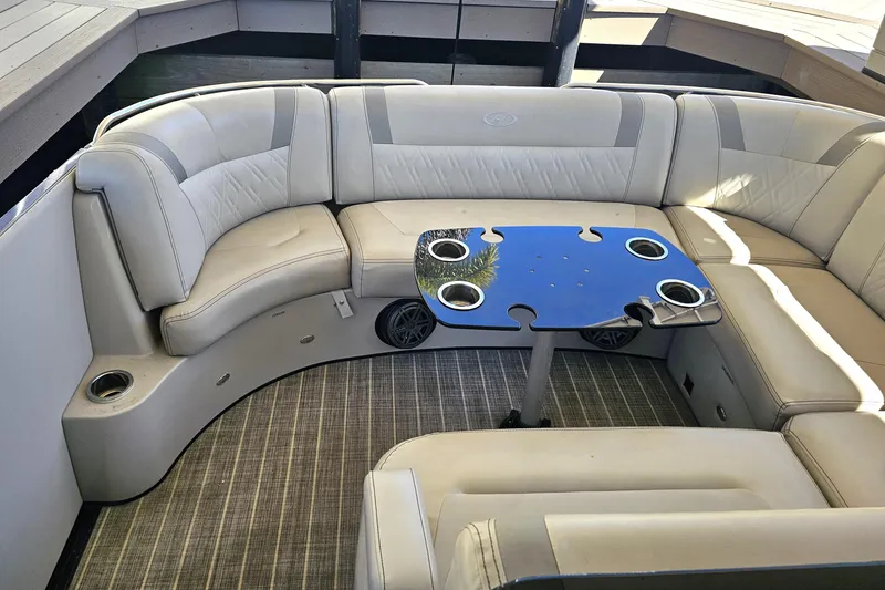 Slide: The Image of 2018 Harris V270 pontoon boat with blue exterior and beige seating, docked in a marina. - 18