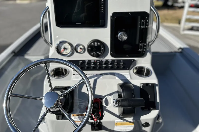 Slide: The Image of 2026 Avid 21 FSX boat dashboard with steering wheel and control panel. - 21