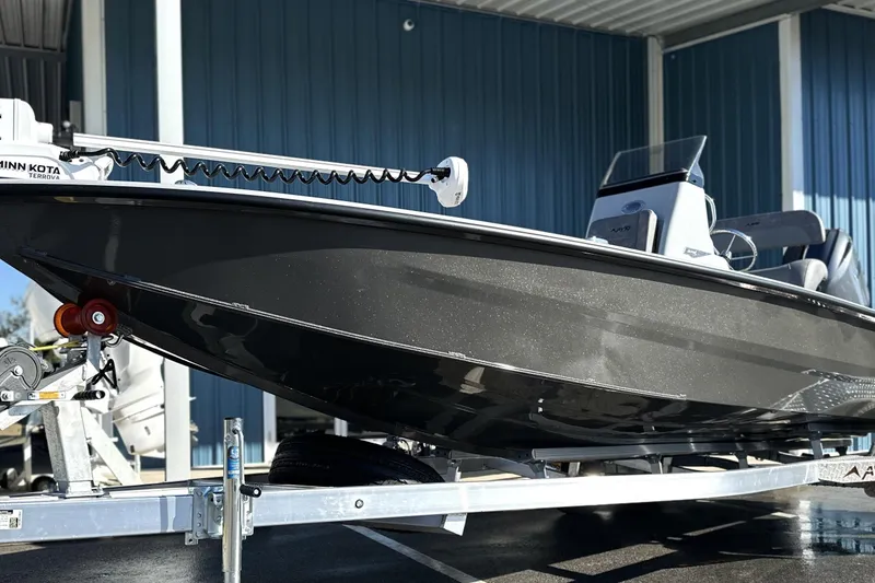 Slide: The Image of 2026 Avid 21 FSX boat on trailer, sleek design, under a metal canopy. - 3