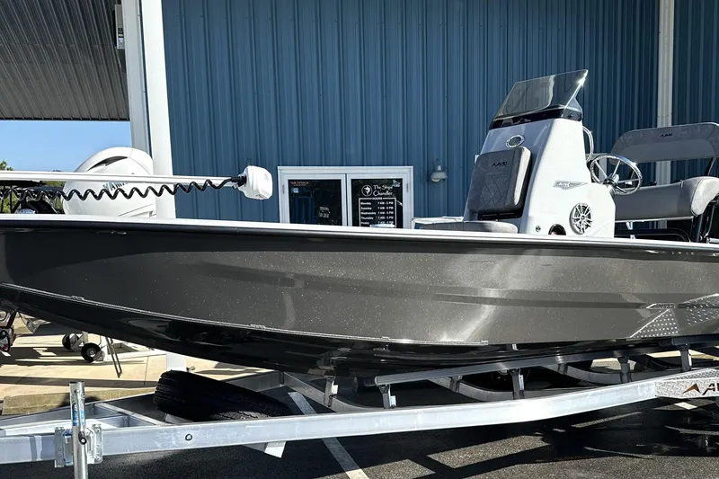 Slide: The Image of 2026 Avid 21 FSX boat on trailer, parked outside a blue building. - 4