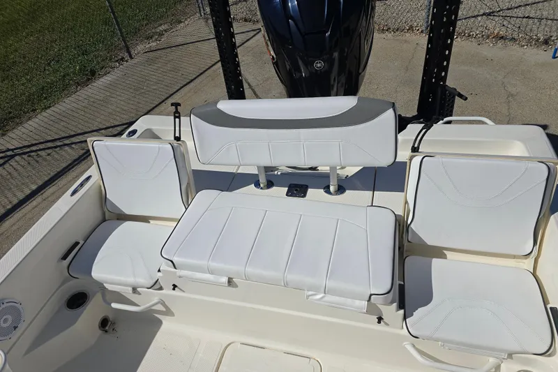 Slide: The Image of 2023 Skeeter SX230 boat seating area with white cushioned seats and motor. - 13