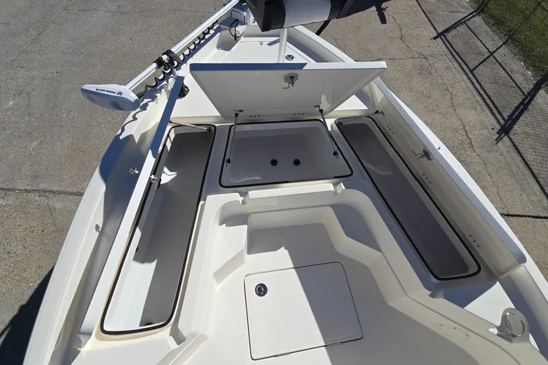 Slide: The Image of 2023 Skeeter SX230 boat deck with open storage compartments and trolling motor. - 19