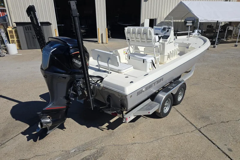 Slide: The Image of 2023 Skeeter SX230 boat on trailer with Yamaha outboard motor, parked outside a warehouse. - 3