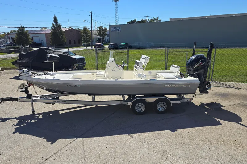Slide: The Image of 2023 Skeeter SX230 boat on trailer, parked outdoors in a sunny area. - 6