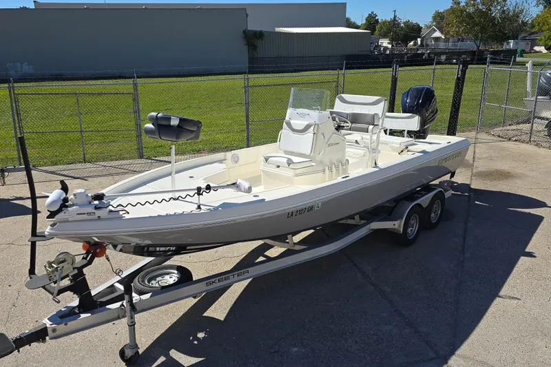 Slide: The Image of 2023 Skeeter SX230 boat on trailer, parked outdoors, featuring modern design and equipment. - 8