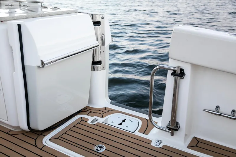 Slide: The Image of Manufacturer Provided Image: Boston Whaler 320 Vantage 2021 boat deck with teak flooring and stainless steel railing. - 10