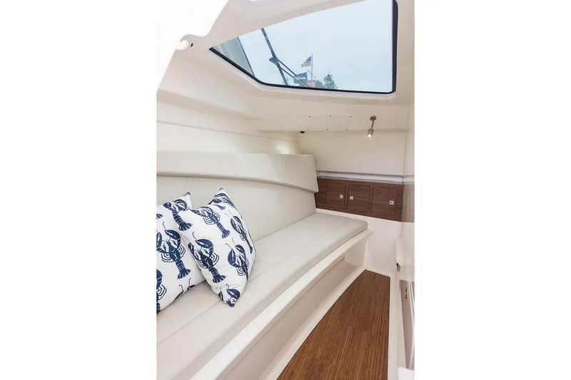 Slide: The Image of Manufacturer Provided Image: Interior cabin of 2021 Boston Whaler 320 Vantage with skylight and nautical-themed pillows. - 21