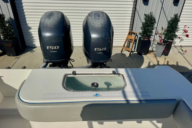 Slide: The Image of 2013 Contender 25 Tournament boat with dual Yamaha 150 engines, docked outdoors. - 6