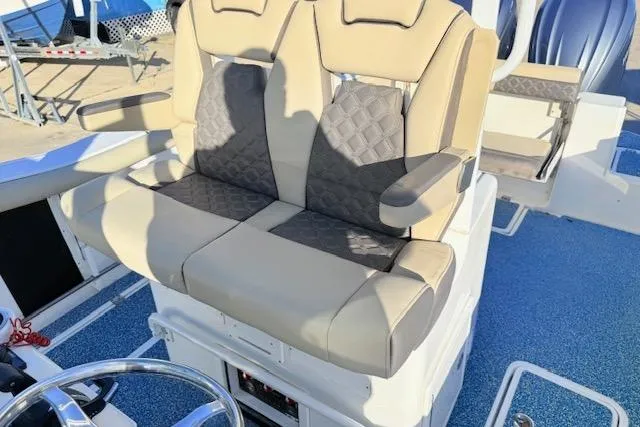 Slide: The Image of 2021 Tidewater 292 CC Adventure boat with beige and gray cushioned seating. - 10